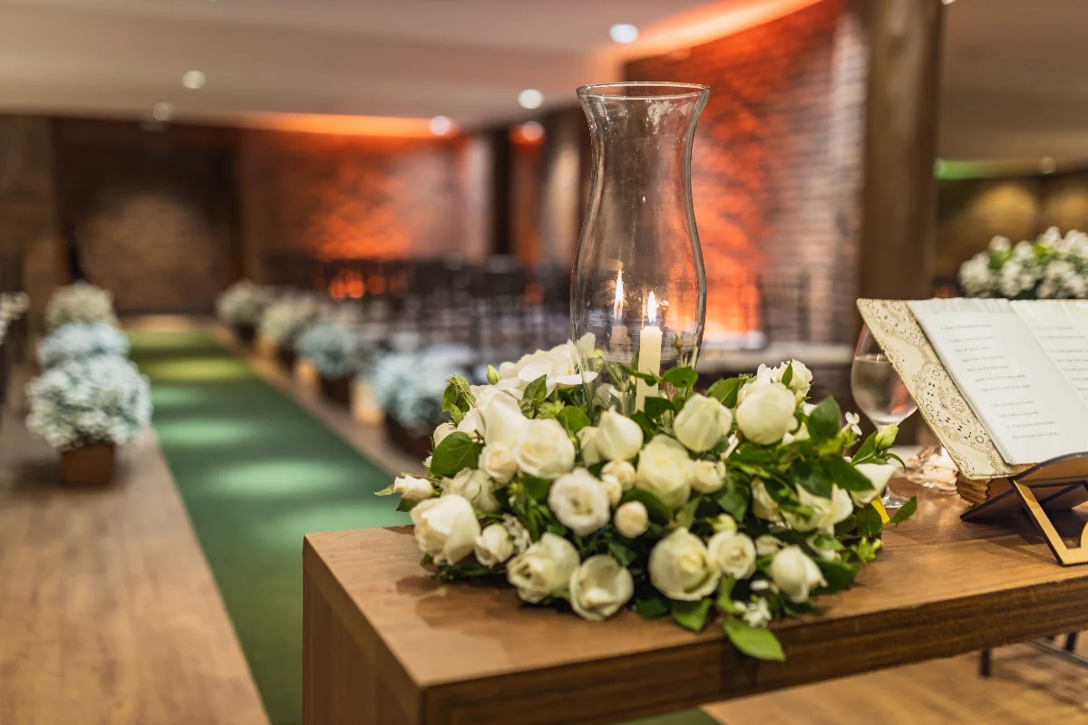 A close-up of a beautiful white rose arrangement at an indoor wedding venue.