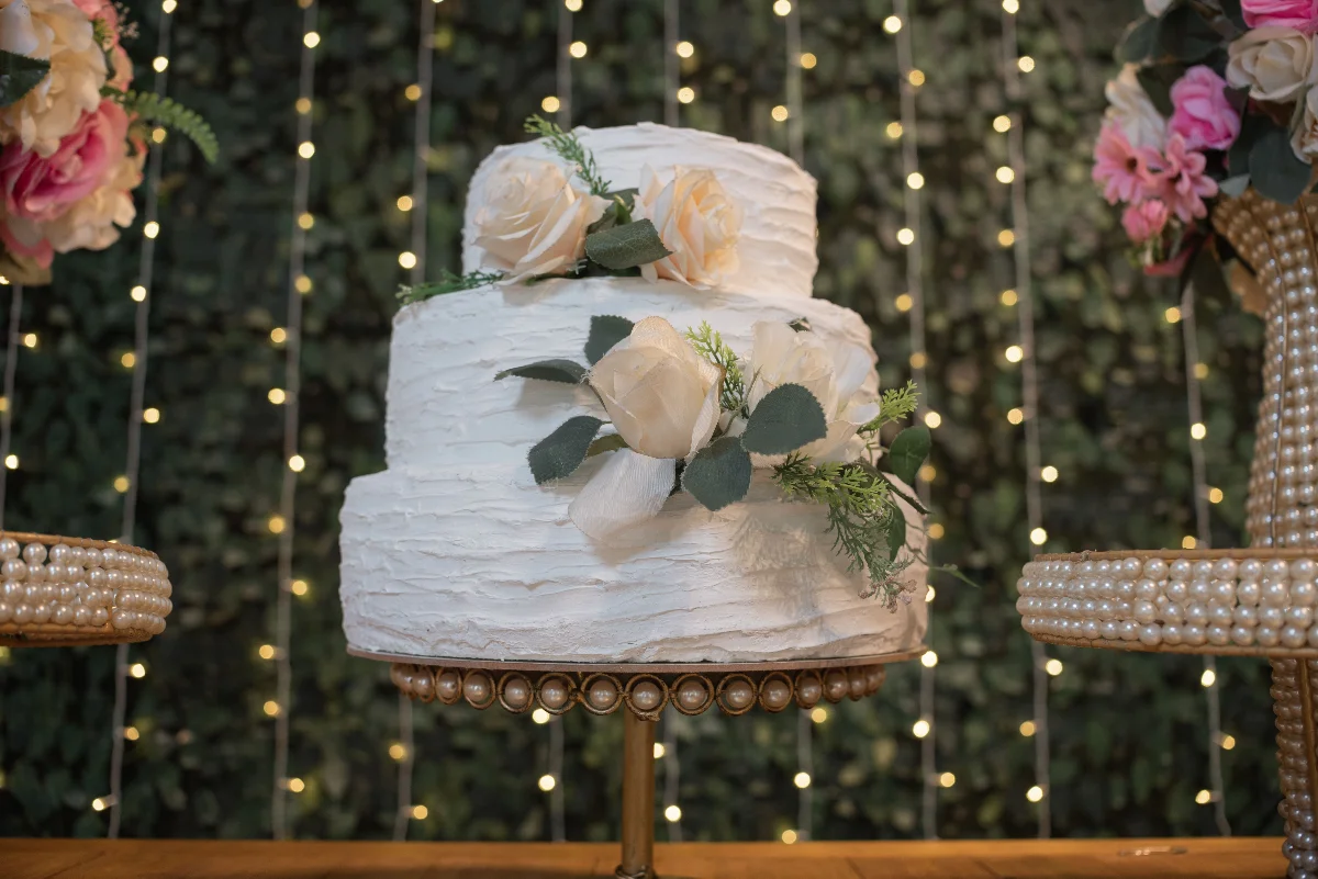 Beautiful two-tier wedding cake adorned with white roses ideal for elegant events.