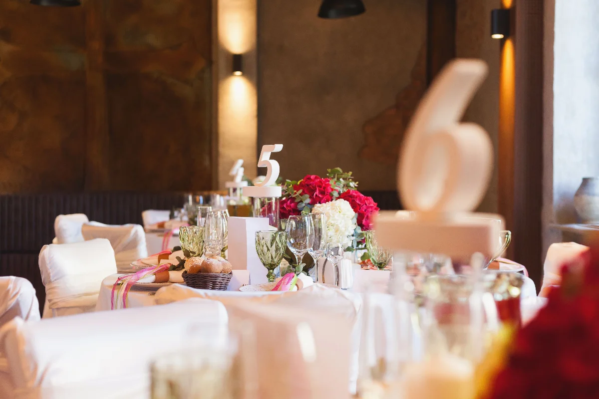 Elegant table setting for a special event featuring floral centerpieces and decorative table numbers.