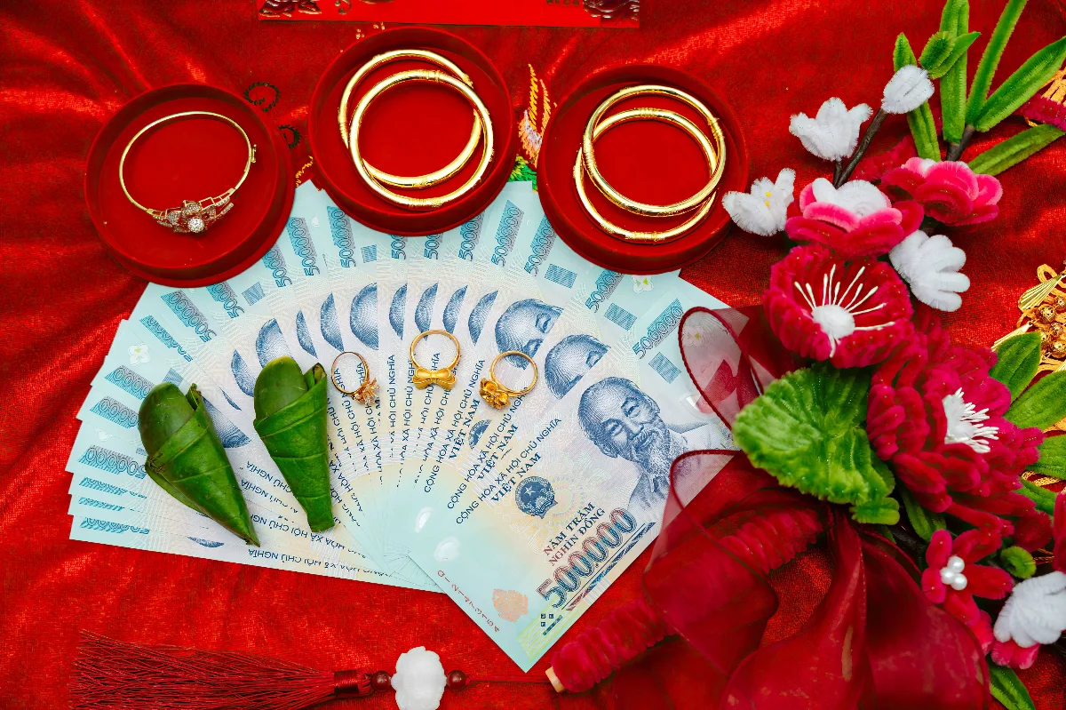 A vibrant display of Vietnamese wedding offerings including money, jewelry, and flowers.