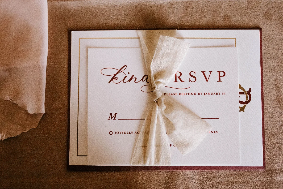 Top view of wedding invitation card for guest with RSVP abbreviation requiring respond from invitee