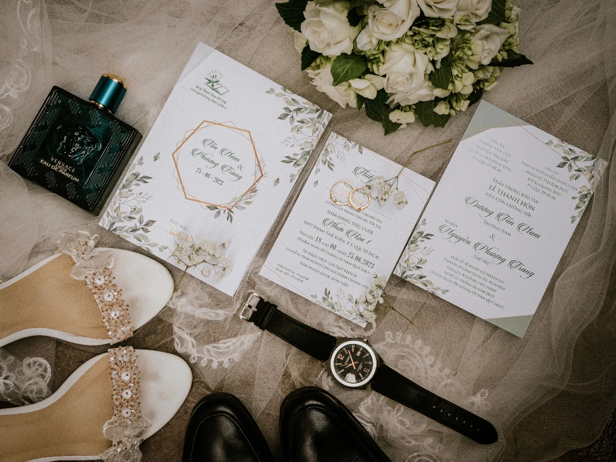 A stylish flat lay of wedding essentials featuring shoes, rings, and a bouquet.