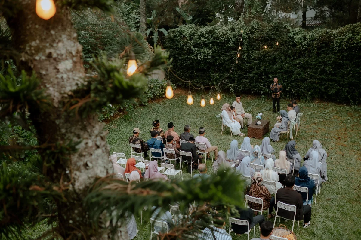 Beautiful outdoor wedding ceremony with guests in a garden setting, captured from above.